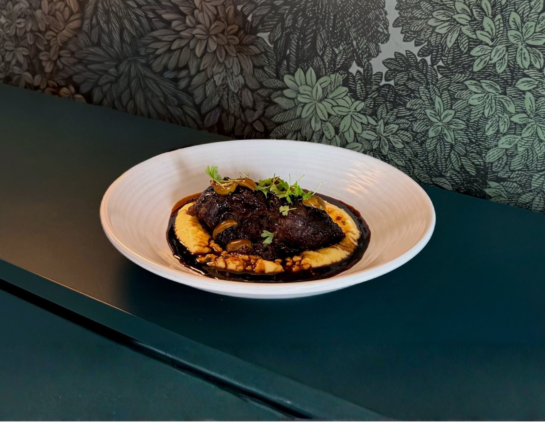 Slow-Cooked Beef Cheeks, Creamy Polenta, Green Olives, Red Wine Jus