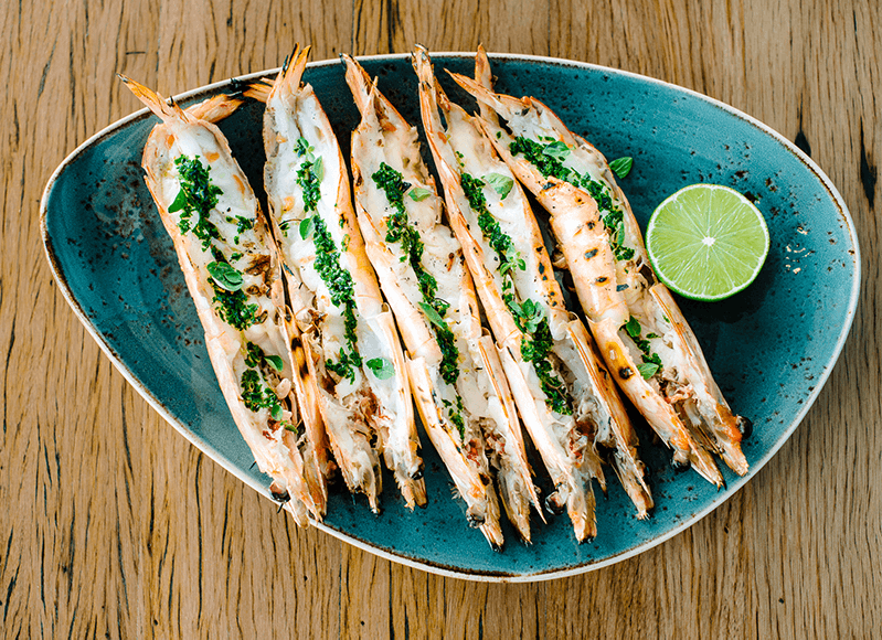 Grilled Prawns with oregano and lime on blue plate
